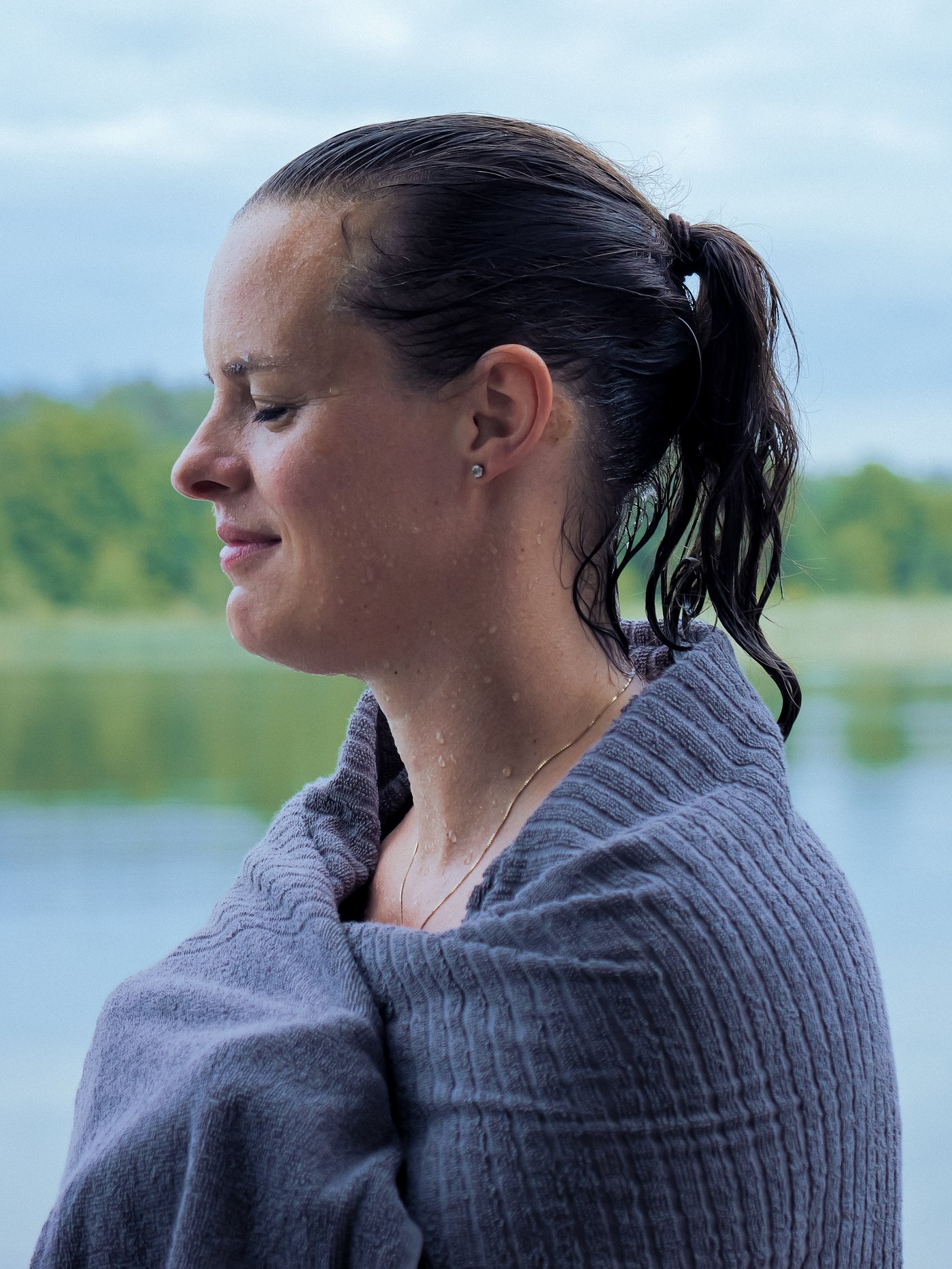 Una donna si avvolge in un asciugamano VÅGSJÖN dopo aver nuotato nell'acqua fredda.