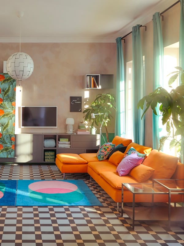 A daytime living room where SÖDERHAMN sofas and other furniture have been either moved to the walls or covered with fabric.