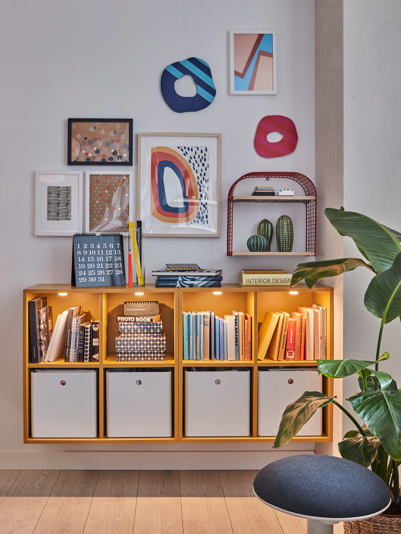 Un estante KALLAX empotrado en una pared y sobre él un grupo de marcos de fotos puestos en diferentes direcciones.