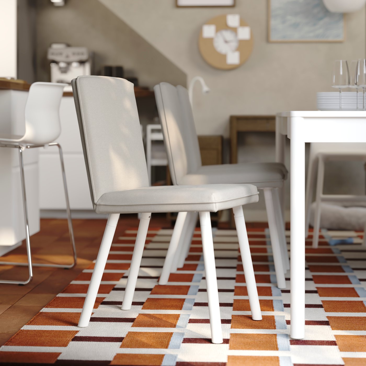 A bright dining room has a TONSTAD extendable table in off-white with several matching chairs around it.