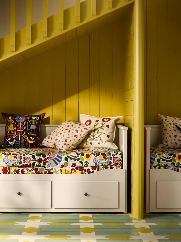 A light blue/multicolour KORALLBUSKE cushion cover in the bedroom