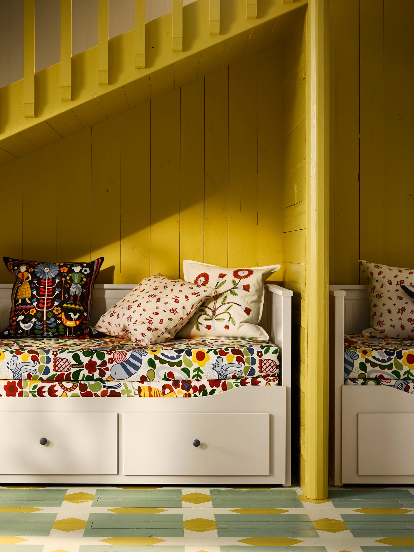 A light blue/multicolour KORALLBUSKE cushion cover in the bedroom