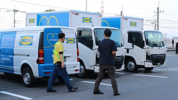 イケアの電気自動車が駐車場に止まっており、イケアのコワーカーが歩いている