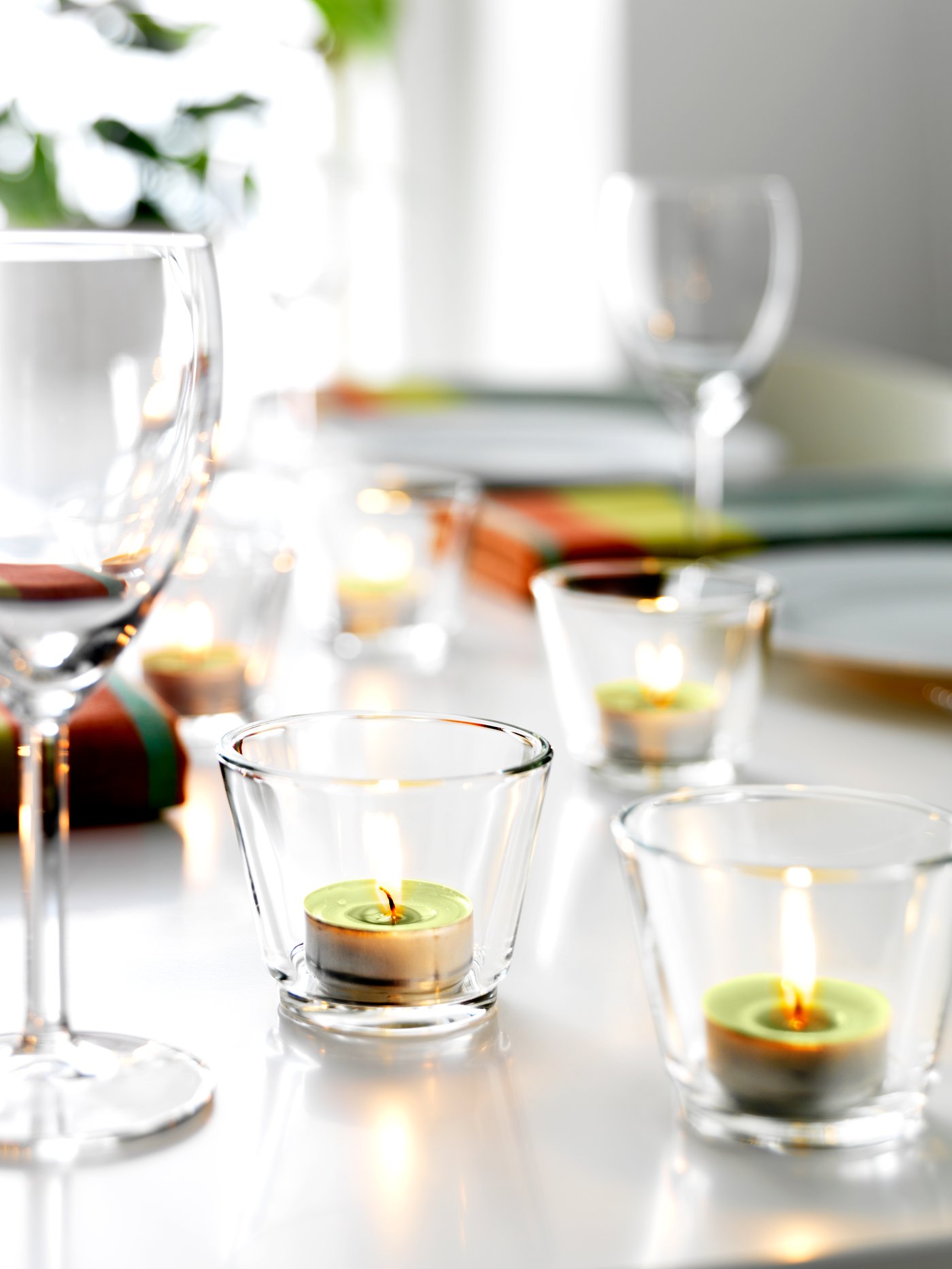 Teelichter in Glashaltern auf einem gedeckten Tisch