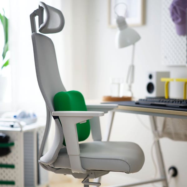 A MATCHSPEL gaming chair in BOMSTAD light grey with a LÅNESPELARE lumbar cushion in green is near an UTESPELARE gaming desk.