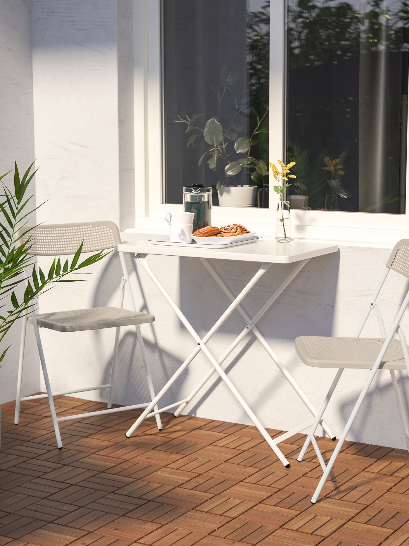 A white/beige TORPARÖ table and 2 folding chairs, outdoor