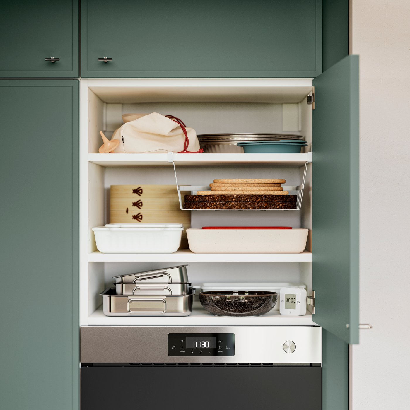 A kitchen cabinet has an open door with kitchen items stored on the shelves inside. One shelf has a PÅLYCKE clip-on basket.