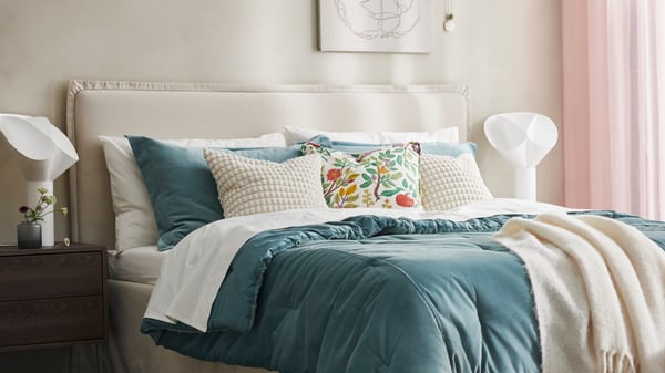 A white multicolour/floral pattern VILDPERSILJA cushion cover in the bedroom