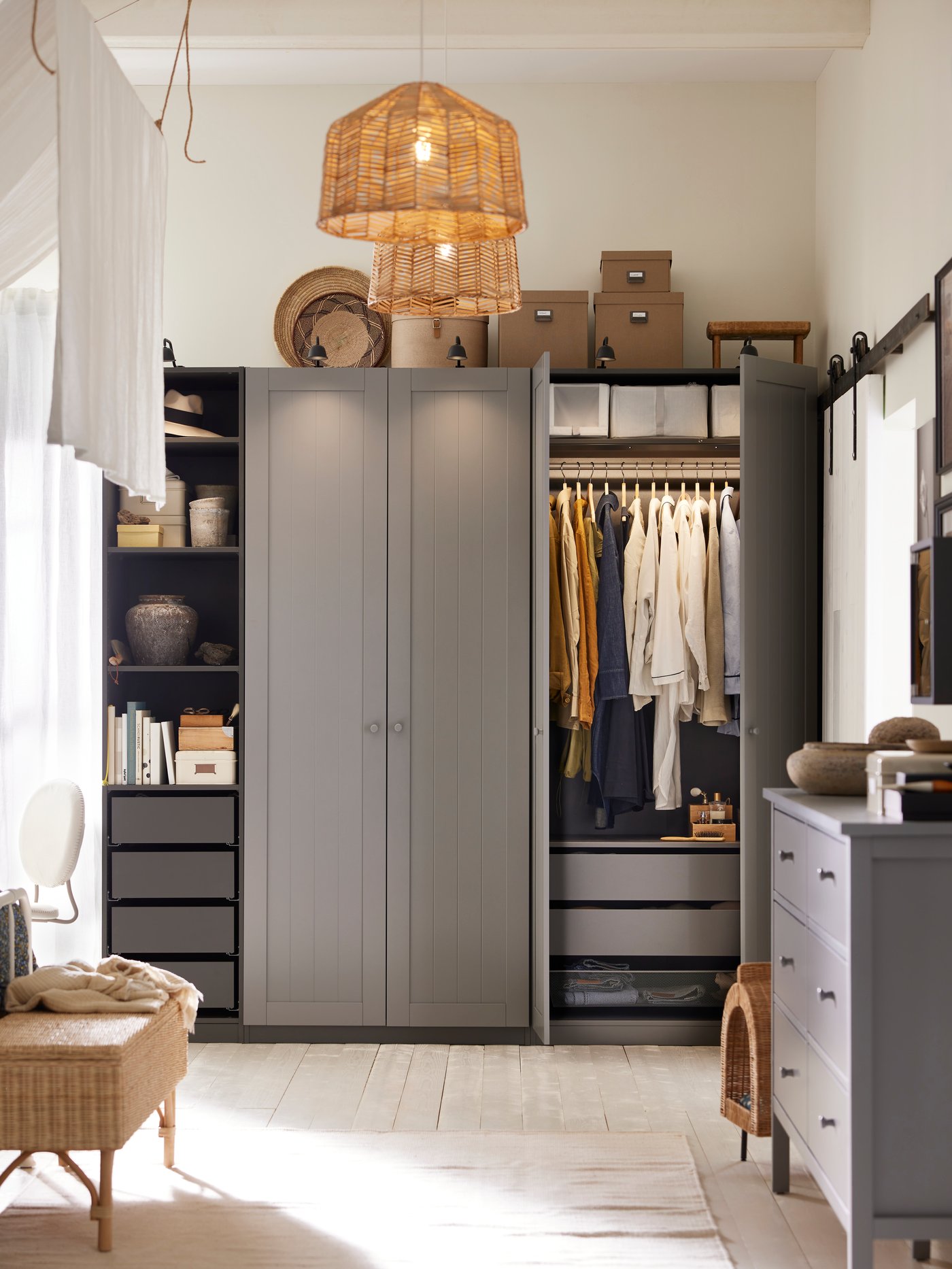 A dark grey/grey PAX/GULLABERG wardrobe combination has two doors open showing clothes on a rail and shoe boxes on a shelf.