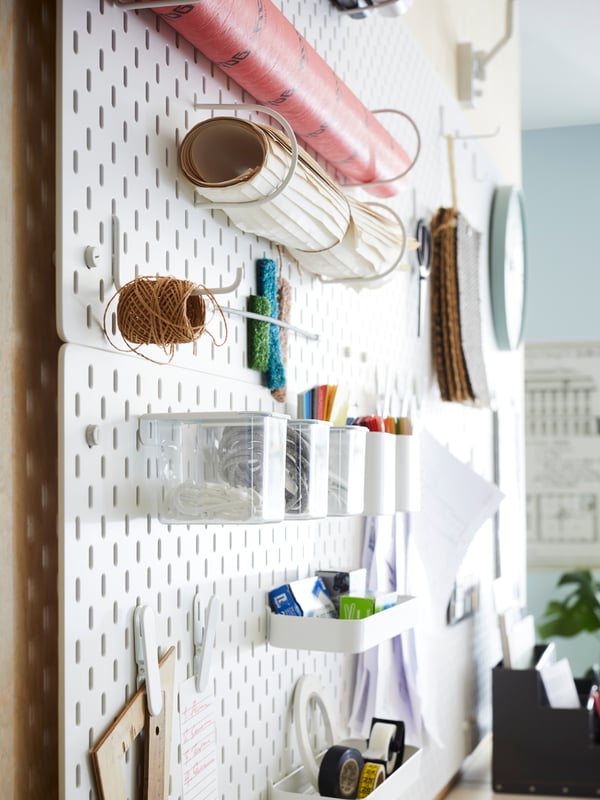SKÅDIS white pegboards holding various office supplies in a communal area of the office.