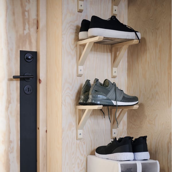 Two sets of two aspen SANDHULT brackets on a light wood wall, one above the other, each holding a pair of shoes.