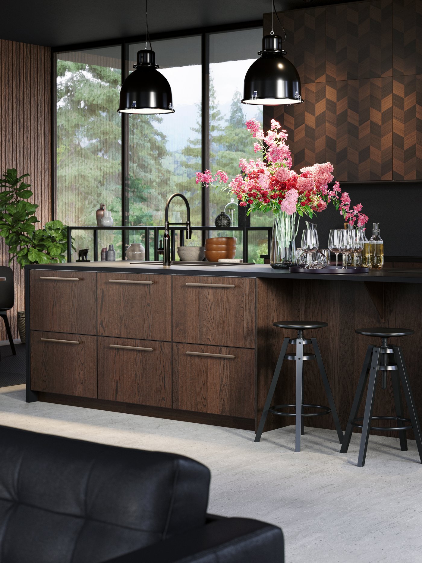 Eine Kücheninsel aus dunklem Holz mit zwei schwarzen Barhockern, zwei schwarzen Hängeleuchten und einer Vase mit einem Blumenarrangement.