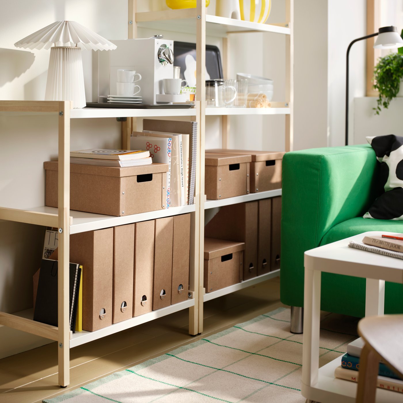 EKENABBEN open shelving units with aspen frames and white metal shelves hold an espresso machine and small storage boxes.