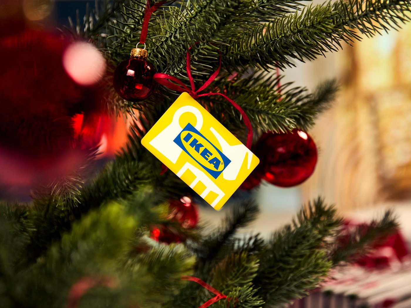 クリスマスツリーに赤いオーナメントとIKEAギフトカードが飾られたホリデーシーン