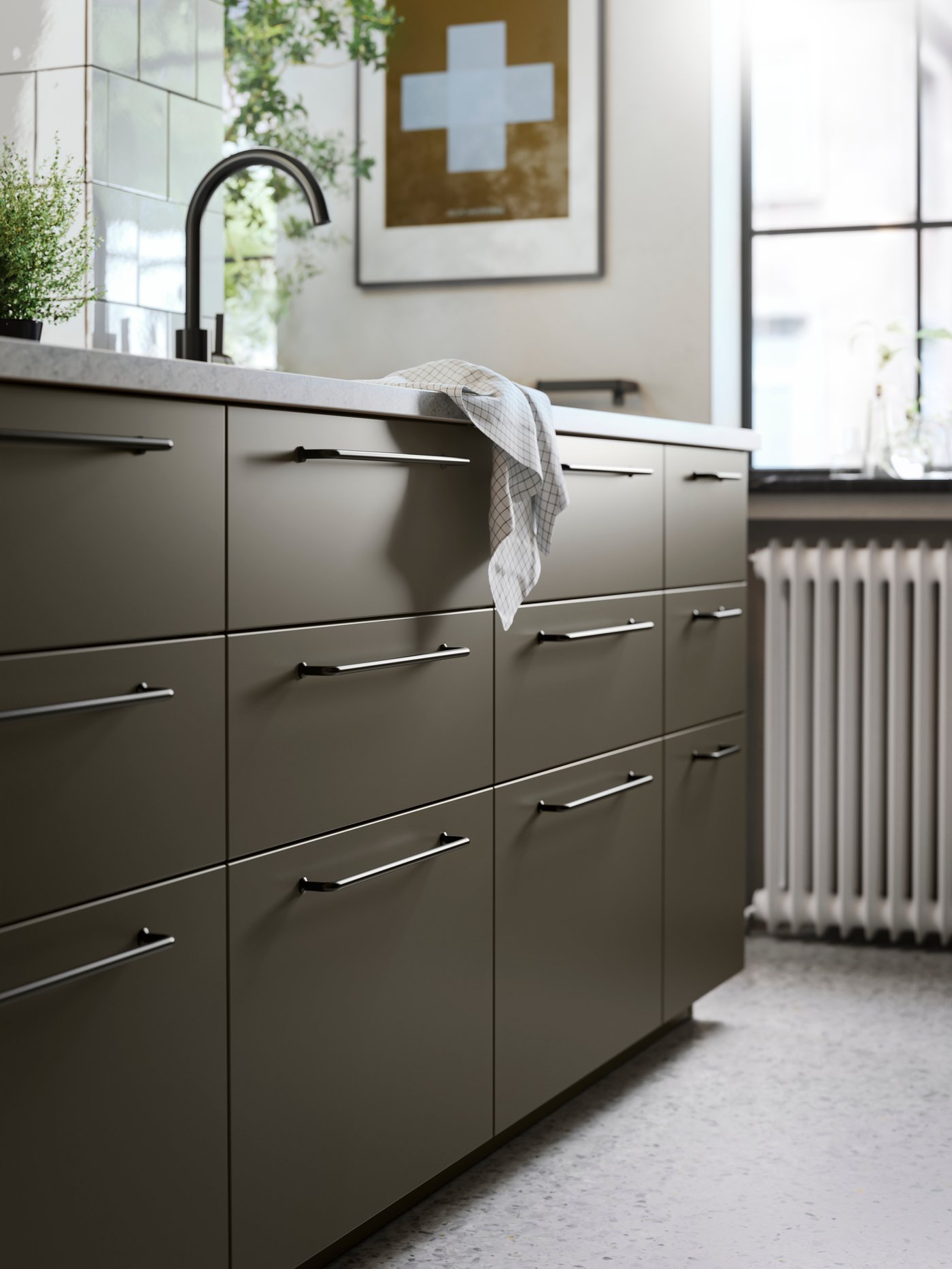 En køkkenø med brun-beige HAVSTORP køkkenfronter, sorte greb, et køkkenbord med kalkstensmønster og en sort vandhane.