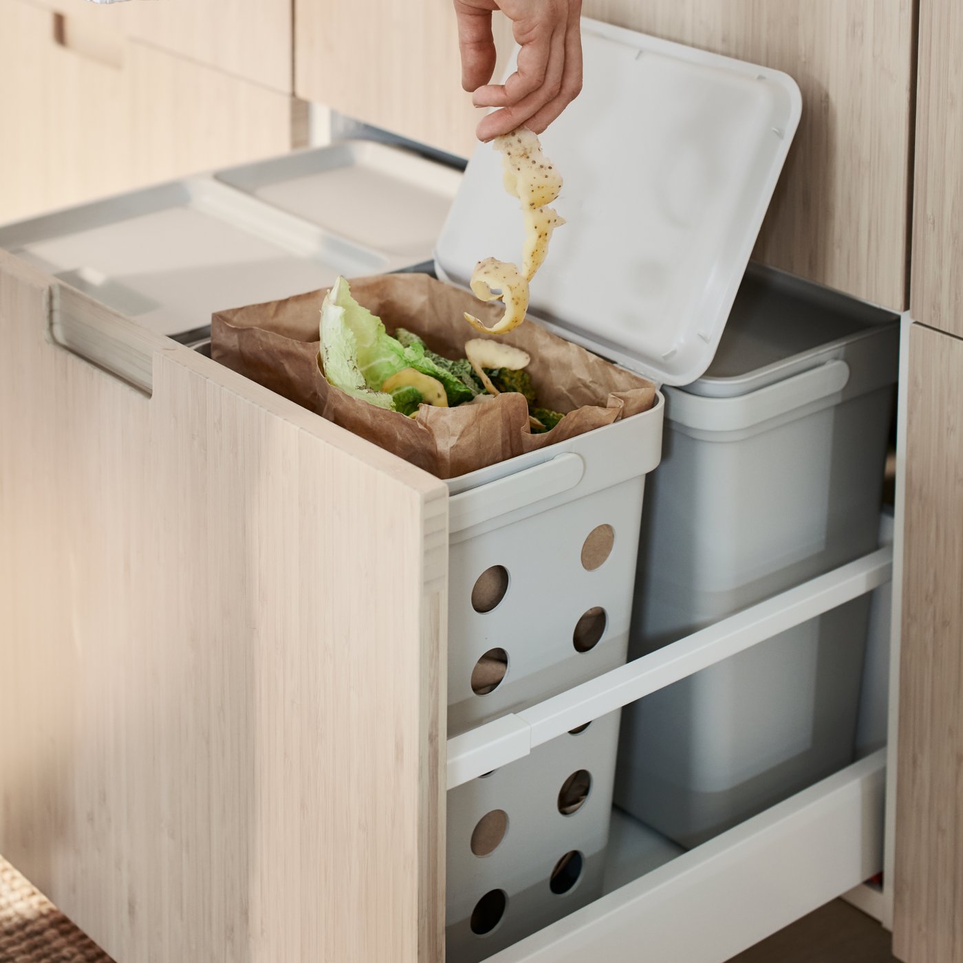 A light grey HÅLLBAR bin with lid in the kitchen