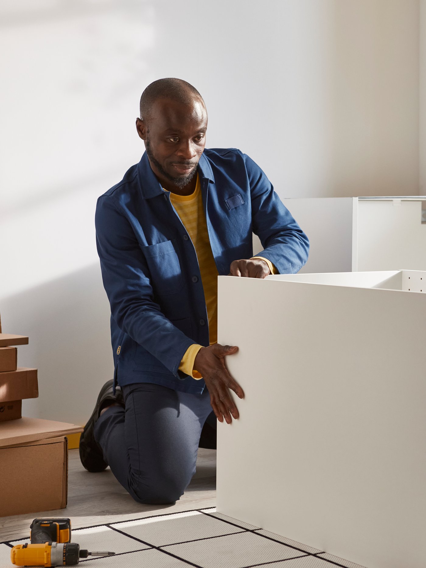 IKEA coworker assembling white kitchen cabinet