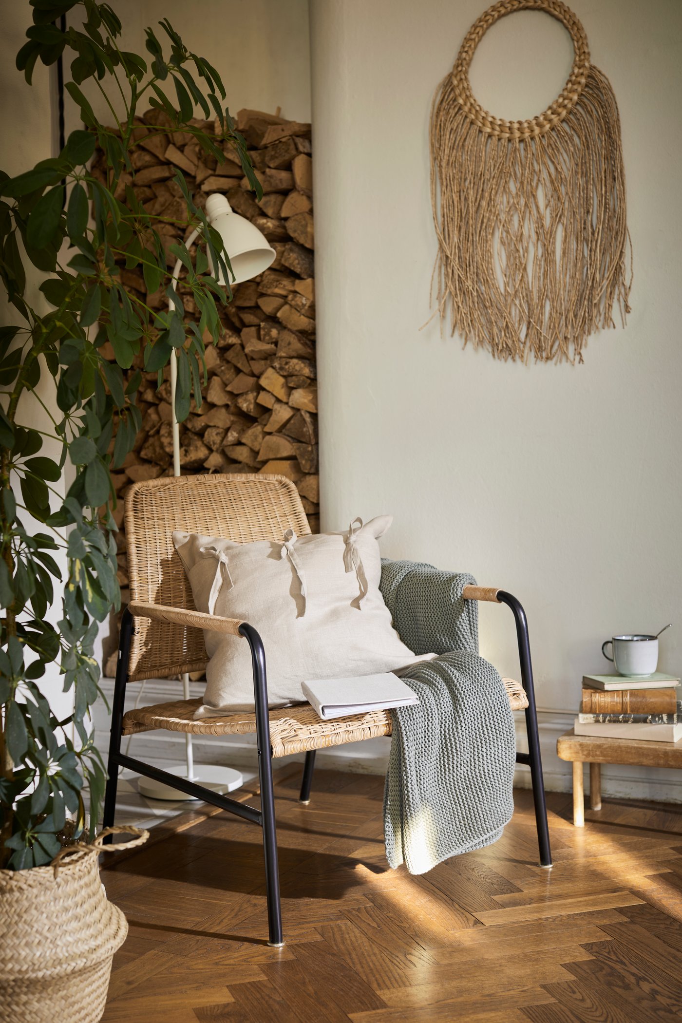 Een zithoek met een rotan ULRIKSBERG fauteuil en een LERSTA vloerlamp/leeslamp.