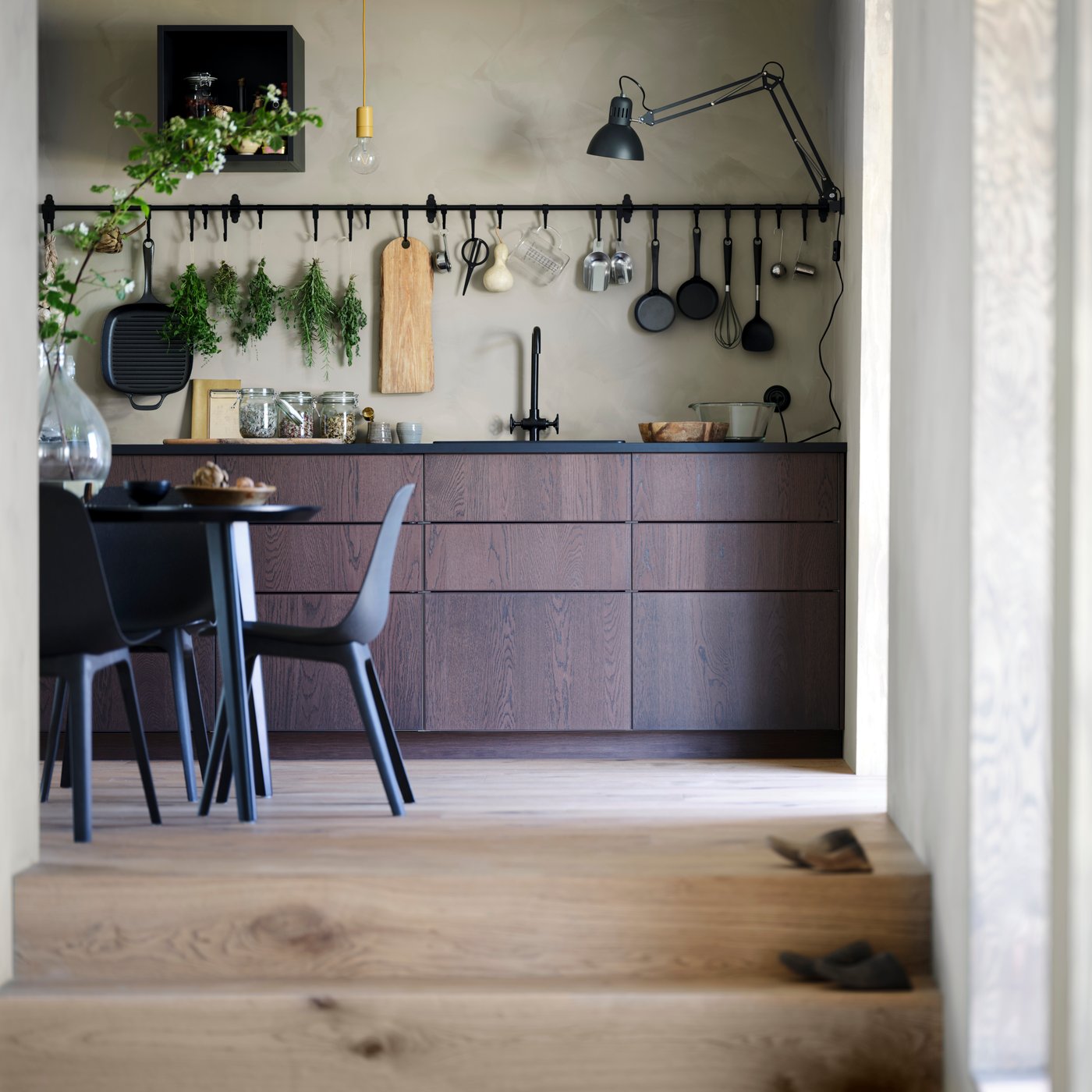 Cucina SINARP con tavolo, sedie e binario con ganci HULTARP sulla parete.