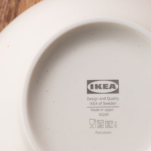 白い磁器皿の裏側に、IKEAのロゴと「Design and Quality IKEA of Sweden」「Made in Japan」などの製品情報や取扱い記号が表示されている。