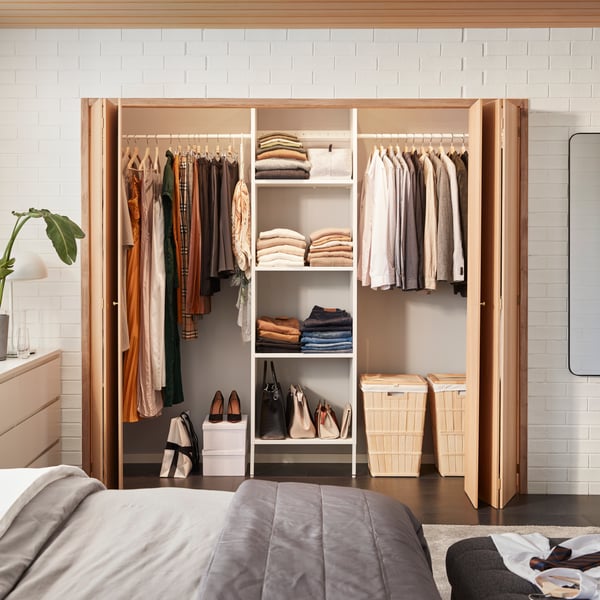 AURDAL open wardrobe placed behind sliding doors.
