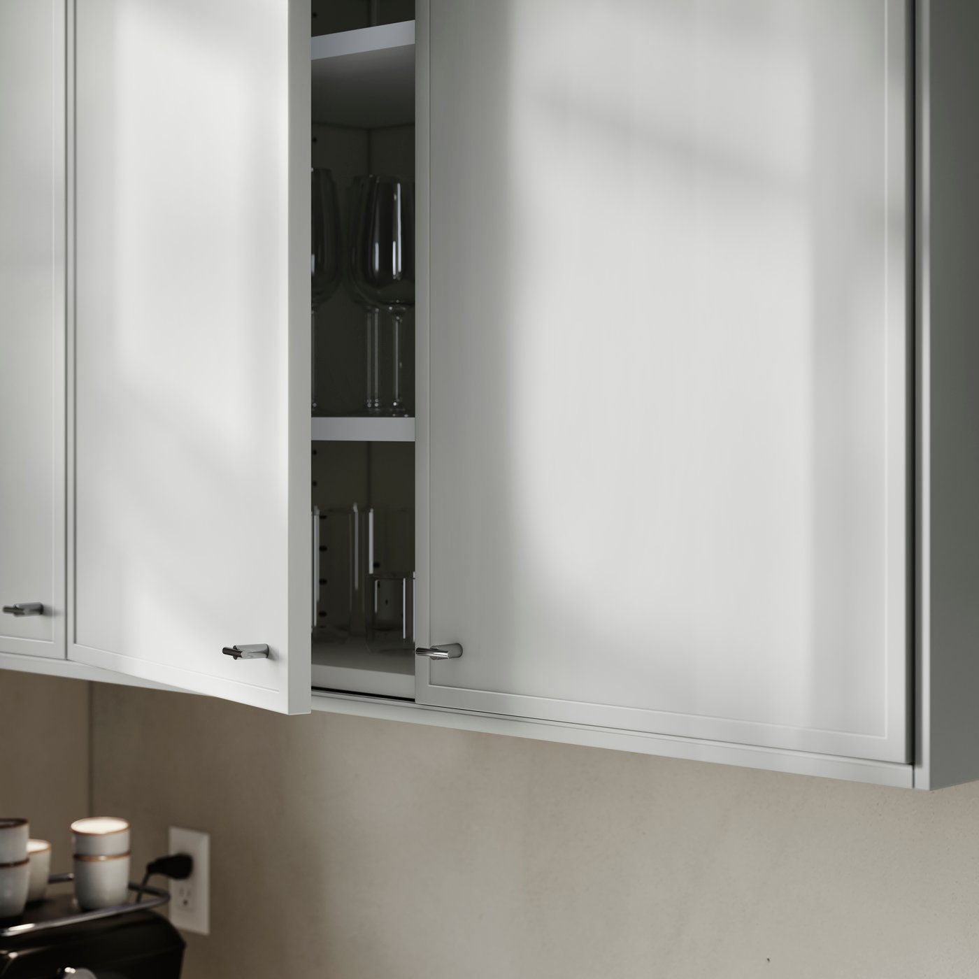 A kitchen cabinet with ASPUDDEN doors in light gray, one slightly open, showing drinking glasses and wine glasses inside.