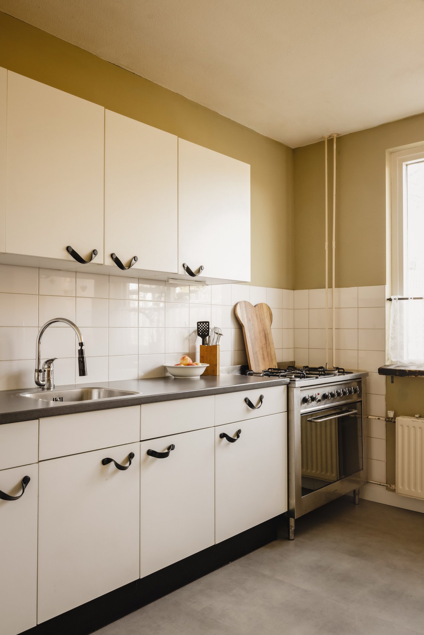 Hoek van de keuken met witte kastjes.
