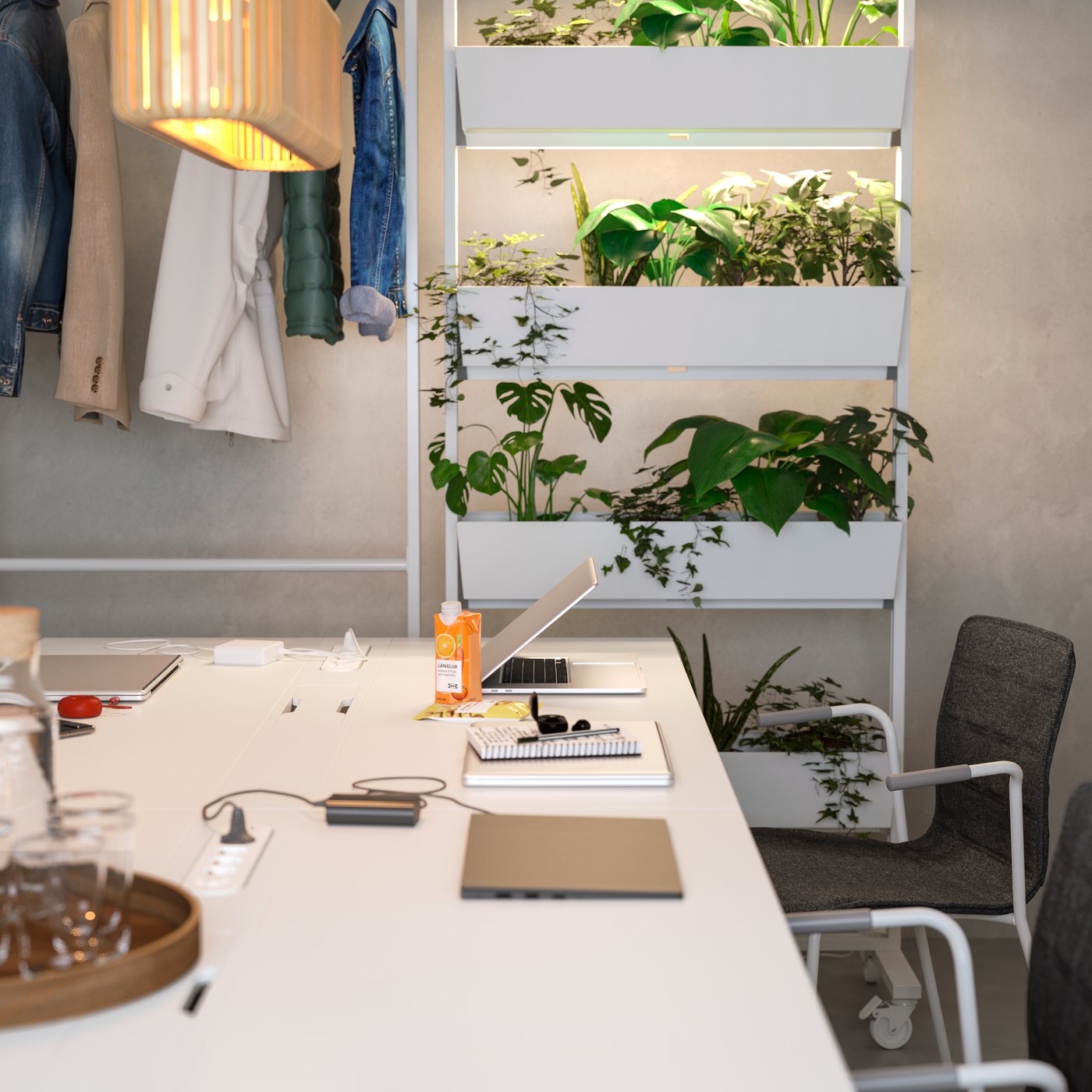 Meeting table with a compartment for charging computers and phones. Gentle lighting and plants create a soft vibe.