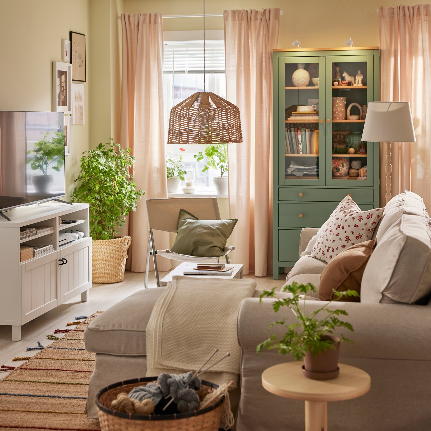 An EKTORP 3-seat sofa with chaise longue stands near a HEMNES glass-door cabinet and a BESTÅ TV bench with doors.