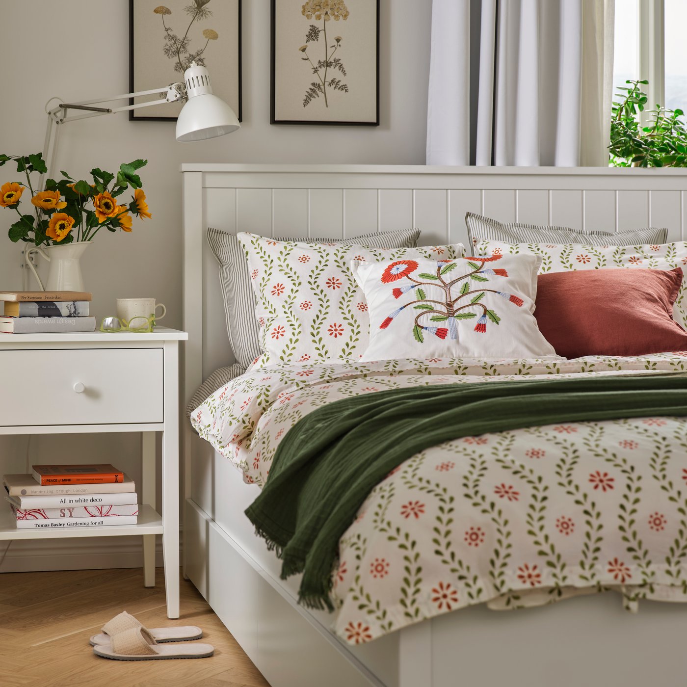 Ein gemütliches Schlafzimmer mit einem Nachttisch und einem Bettgestell von GULLABERG. Auf dem Bett liegt Bettwäsche von FYRISVIDE, dazu Kissen und eine Tagesdecke.