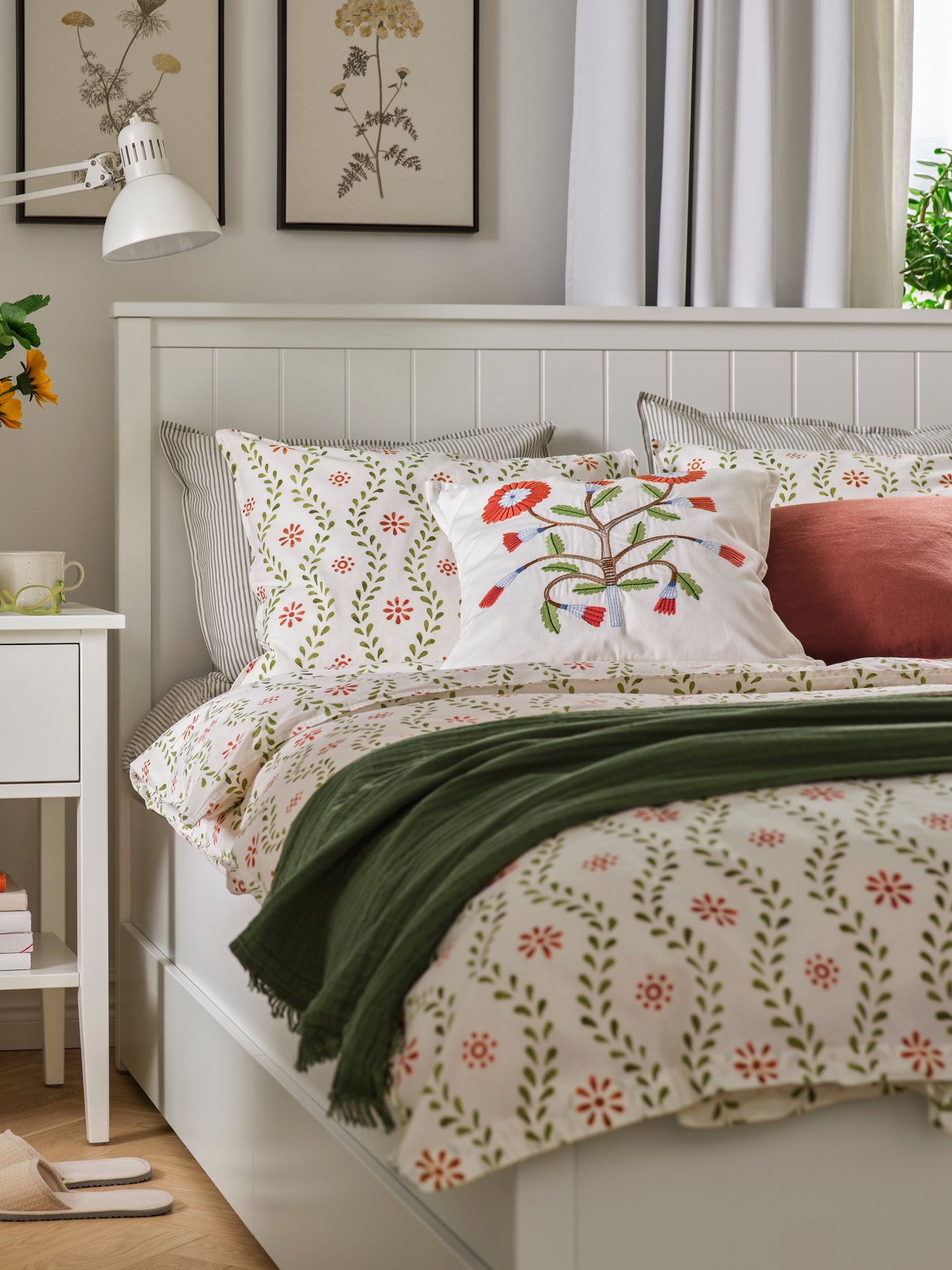 A cosy bedroom with a GULLABERG bedside table and bed frame. FYRISVIDE bed linen is on the bed with cushions and a throw.