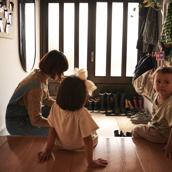 A woman plays with her children in the hall.