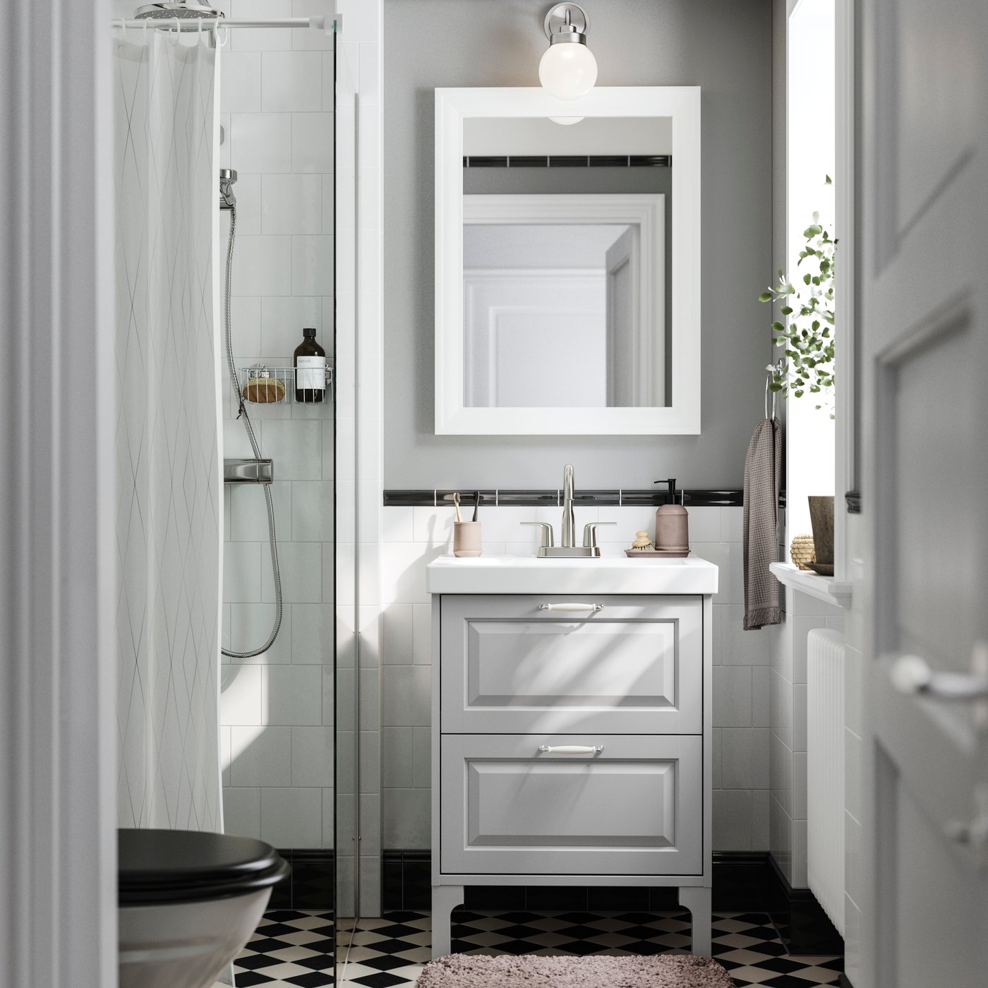 Narrow bathroom with white vanity, framed mirror, shower area, and patterned floor.