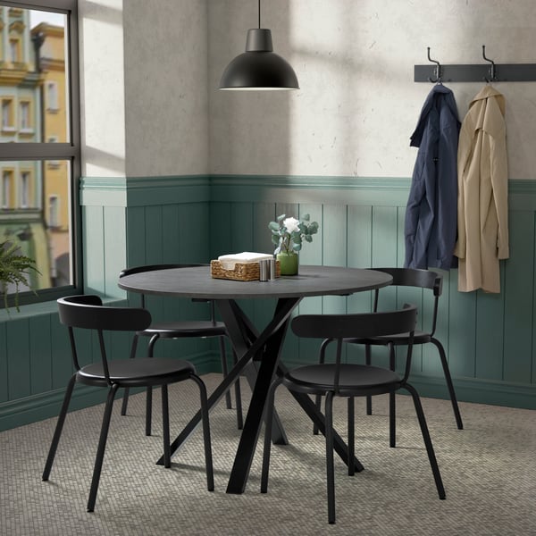 Une table de cuisine noire avec des chaises dans une petite cuisine.