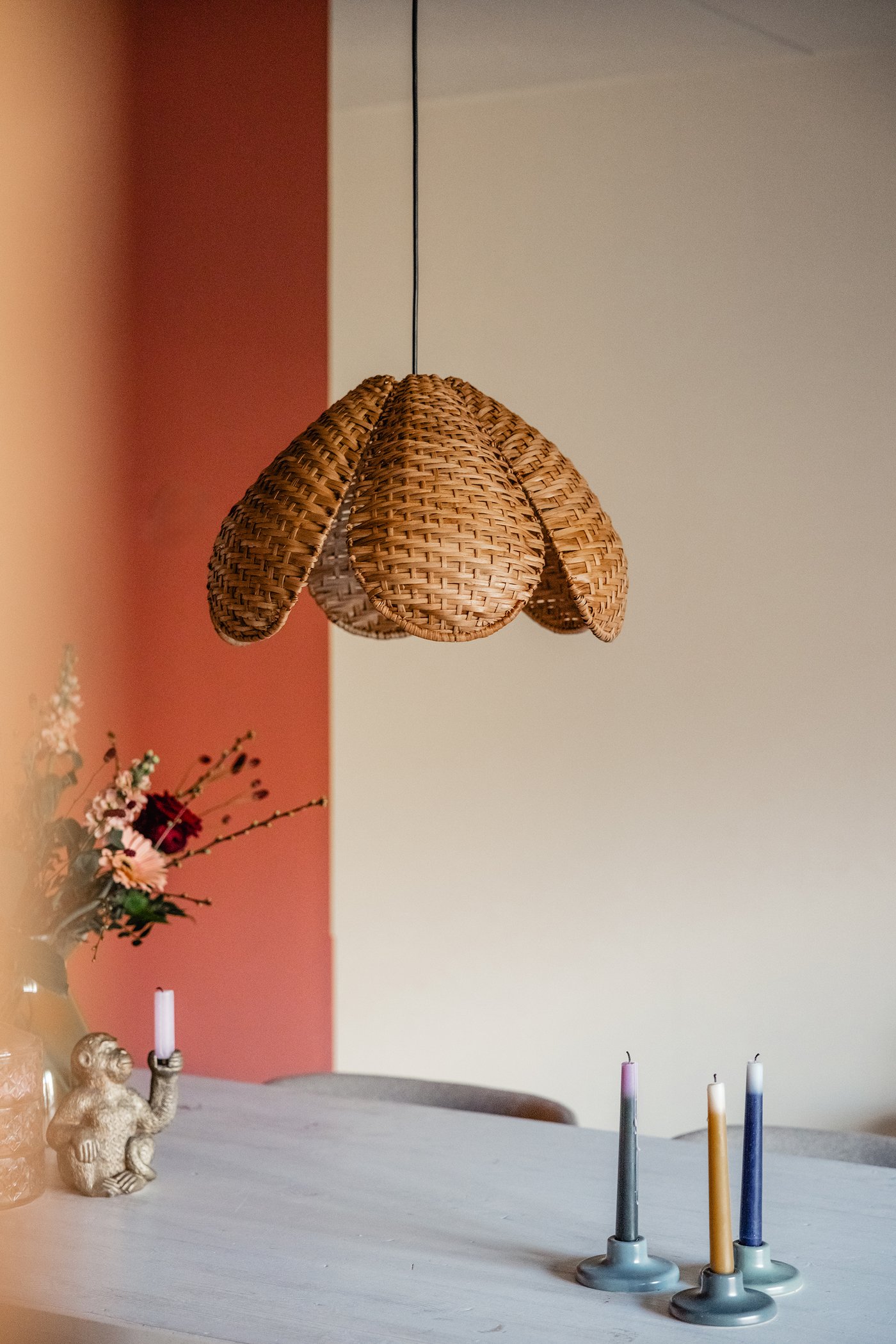 Een eettafel met daarboven een SANDKORN hanglamp van rotan.