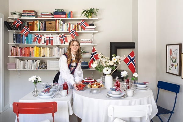 En kvinne står foran sitt dekkede 17. maibord.