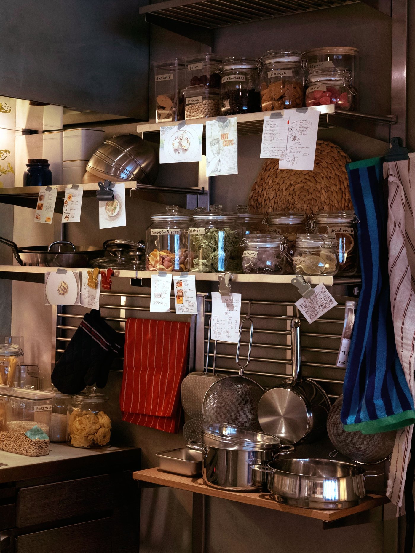 壁一面のシェルフに食器や保存瓶、キッチンツールを並べた温かみのあるキッチン収納
