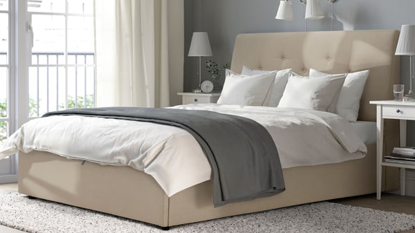  Un pouf imbottito IDANÄS beige Naggen su un letto in camera da letto
