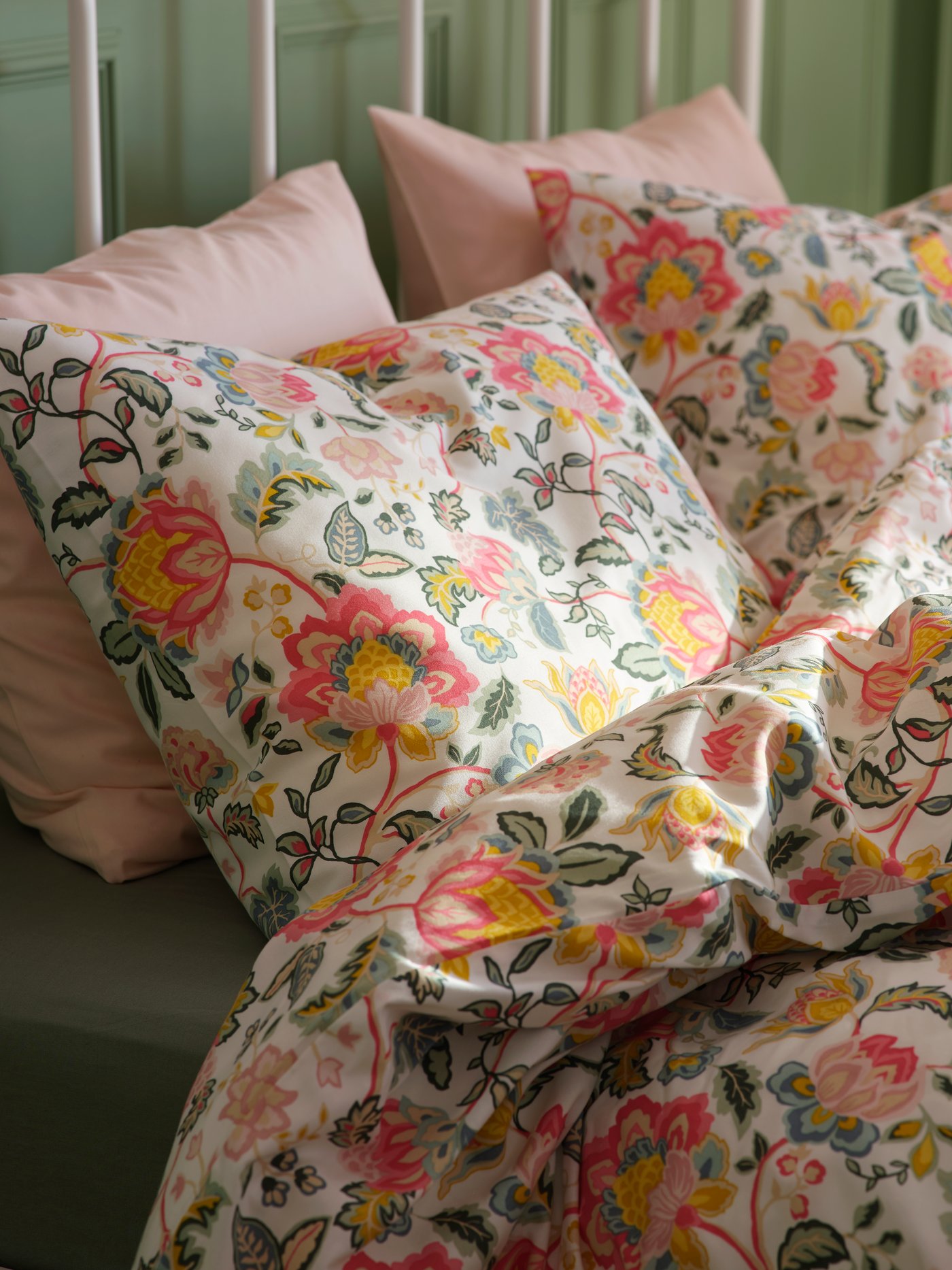 A multicolour DAGGSALVIA duvet cover and pillowcase set featuring a vibrant floral pattern, beautifully arranged on a bed.