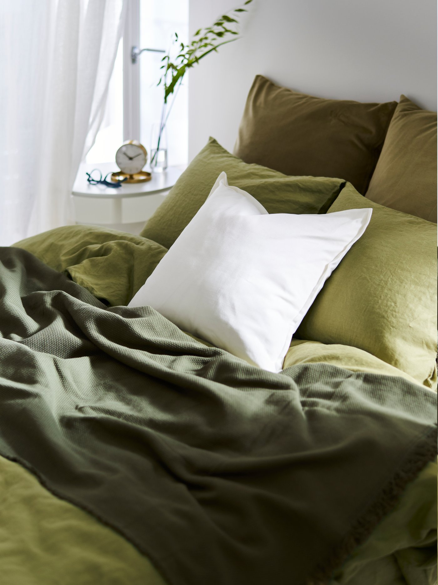 Pale green SILVERLÖNN curtains frame a window while cushions in AINA and RÖDASK cushion covers decorate a VIMLE sofa.