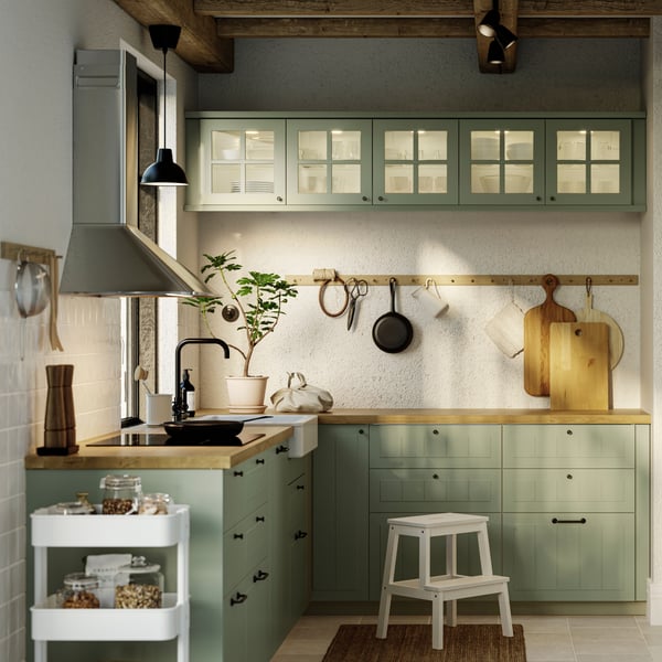 Ett grönt L-format HAVSTORP kök från IKEA ses från sidan.