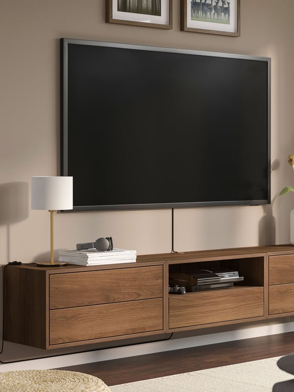 IKEA EKET brown/walnut effect media storage combination mounted as a tv bench in the living room.