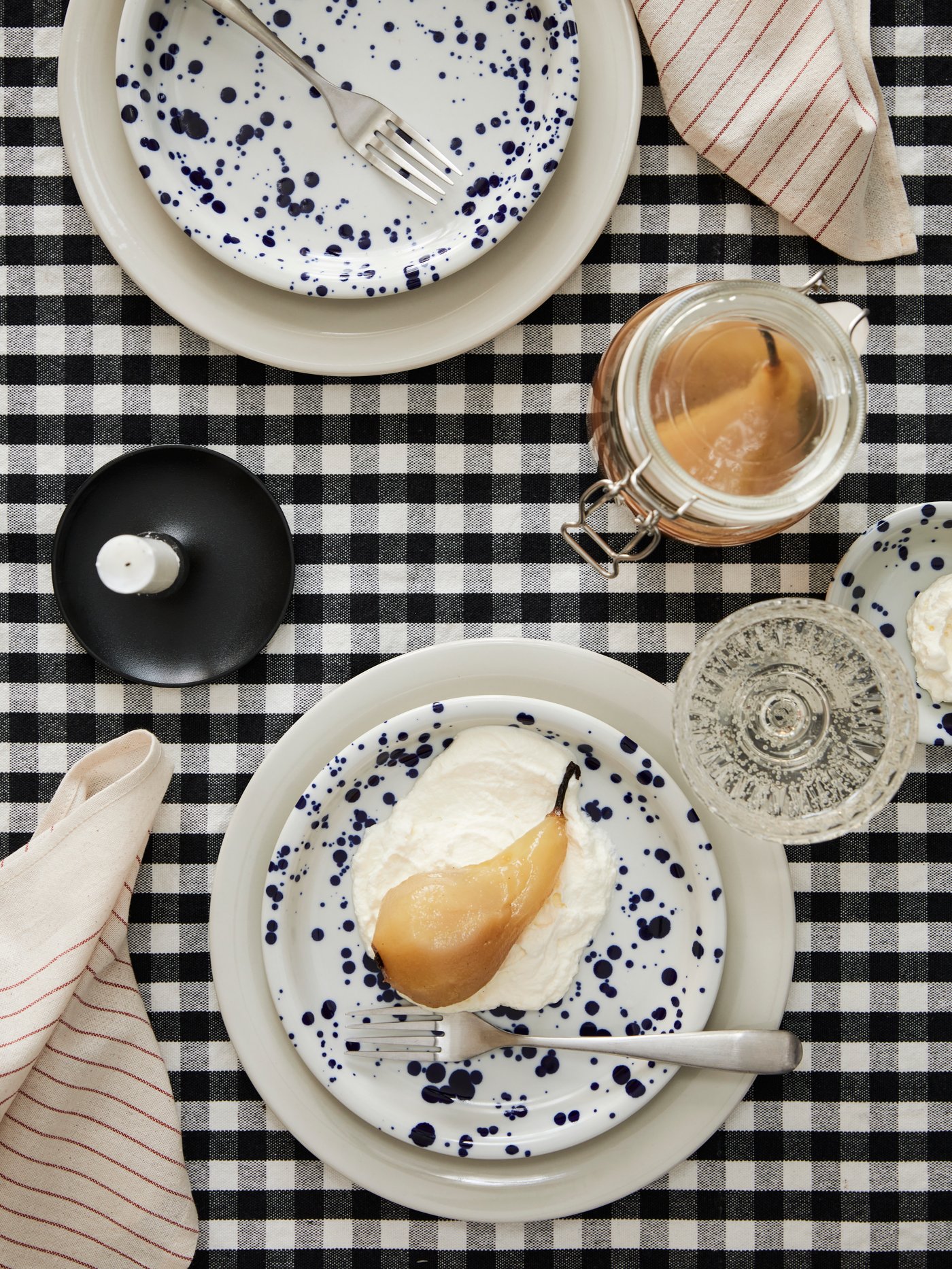 Mønstret/blå SILVERSIDA og lysegråbeige SANDSKÄDDA servicestativ på et bord med en sort og hvid dug.