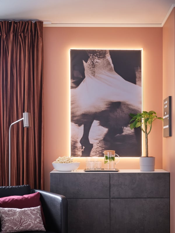 Block-out curtains, a big artwork with LED lighting strips, storage combination with doors/drawers, popcorn, glasses.