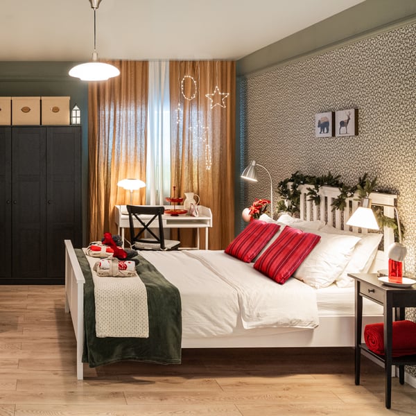 Una camera da letto con copricuscini VINTERFINT a righe rosse e coperte bianche e verdi