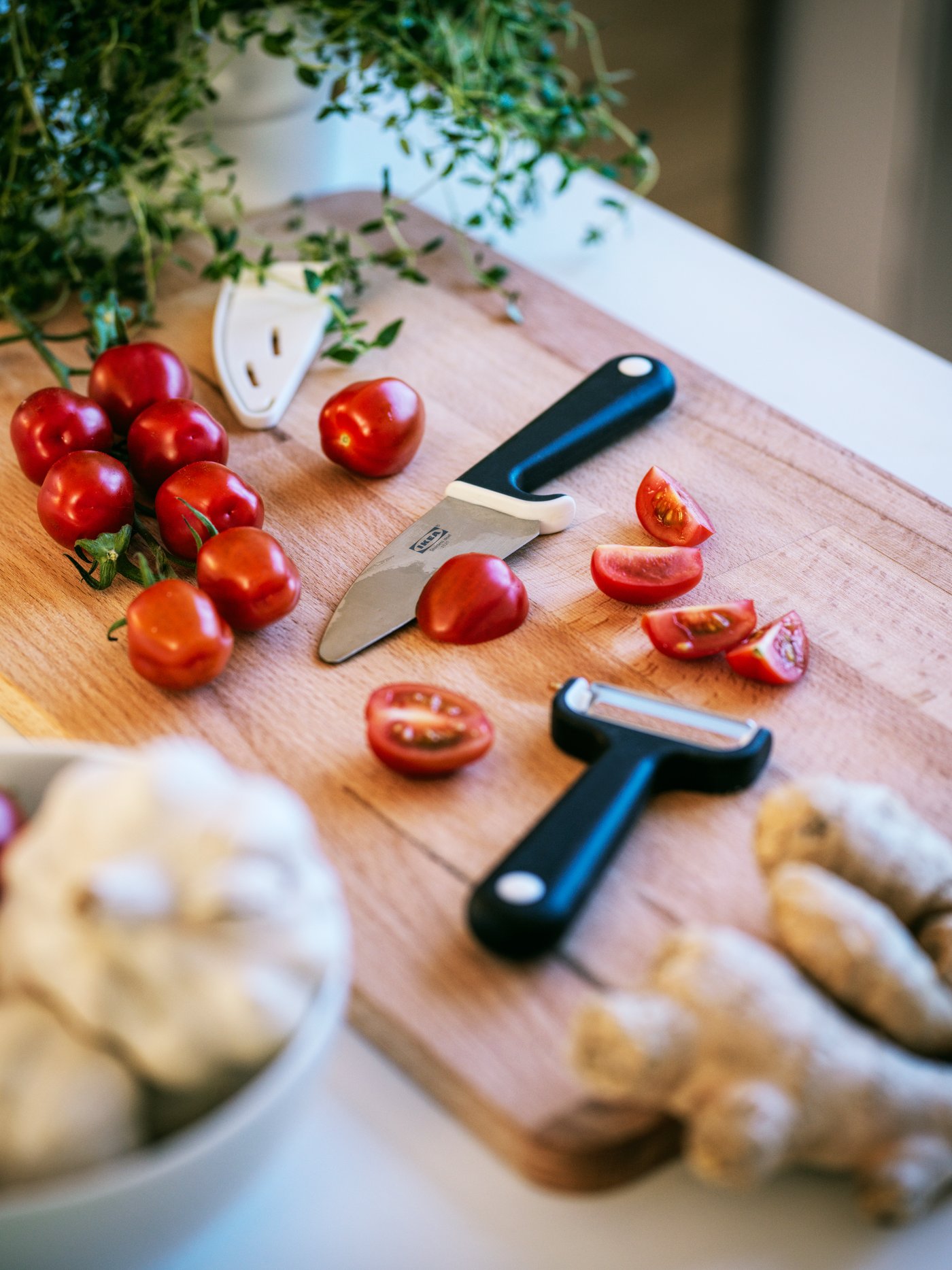 Close-up of the soft, rounded edges of the STOLTHET bamboo chopping board, with sliced lemons on top.