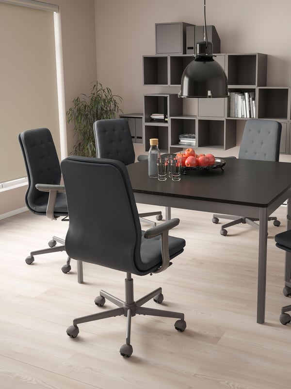 Silla MULLFJALLET de conferencia de color grisaceo oscuro en una sala de oficina.