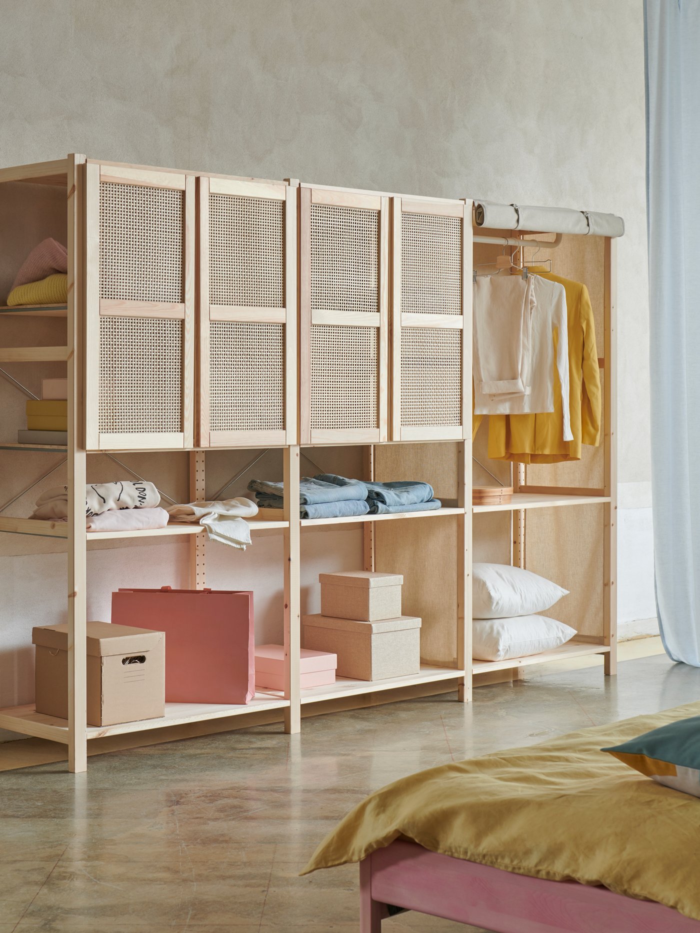 Three sections of IVAR storage system in light pine with four bamboo doors at the top, standing in a bedroom context.