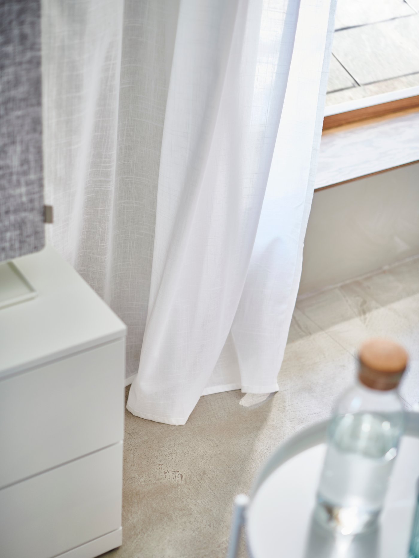 Nårbild på vita, genomskinliga SILVERLÖNN gardinlängder med påsydd veckbandstejp.