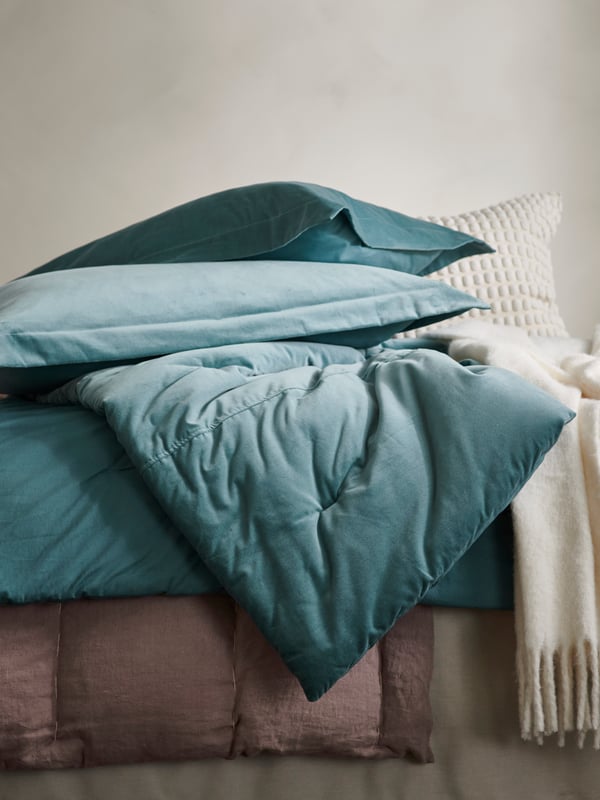 An off-white SVARTPOPPEL cushion cover in the bedroom